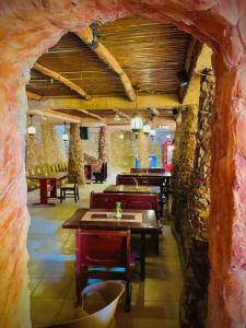 a restaurant with tables and chairs and a stone wall at Eagles Downtown Resort in Hurghada