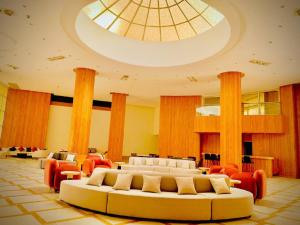 ハルガダにあるEagles Downtown Resortの天井の広い客室で、ソファ、椅子が備わります。