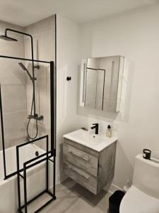La salle de bains est pourvue de toilettes, d'un lavabo et d'une douche. dans l'établissement Chic Modern Apt in The Plateau, à Montréal