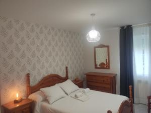 1 dormitorio con cama blanca y espejo en Casa da Carballeira, en A Estrada