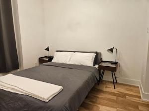 - une chambre avec un lit et une table avec une lampe dans l'établissement Chic Modern Apt in The Plateau, à Montréal