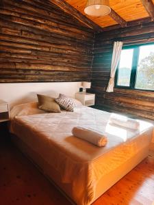 a large bed in a room with wooden walls at Piedra que late in Tandil