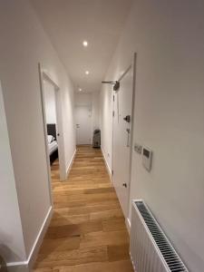 a hallway with white walls and a wooden floor at Lovely apartment in the centre of Croydon in Croydon