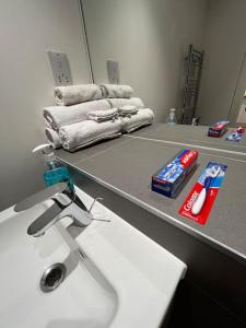 a bathroom with a sink and a mirror and towels at Lovely apartment in the centre of Croydon in Croydon