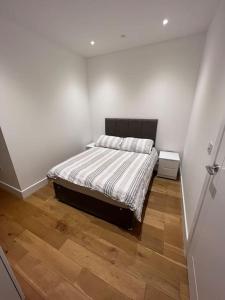 a bedroom with a bed and a wooden floor at Lovely apartment in the centre of Croydon in Croydon