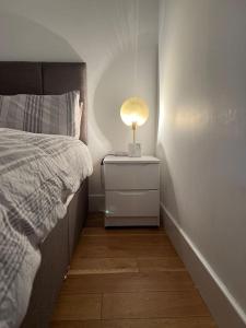 a bedroom with a bed and a lamp on a night stand at Lovely apartment in the centre of Croydon in Croydon