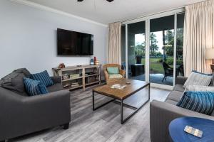 a living room with two couches and a table at Waterscape C206 Ground Floor in Fort Walton Beach