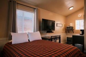 a bedroom with a bed with two pillows and a television at Chinook Wind Cabins in Talkeetna