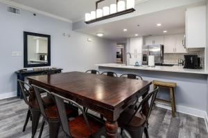 uma cozinha e sala de jantar com uma mesa de madeira e cadeiras em Waterscape C206 Ground Floor em Fort Walton Beach