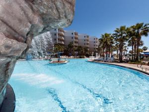 a large swimming pool with a waterfall in a resort at Waterscape C206 Ground Floor in Fort Walton Beach