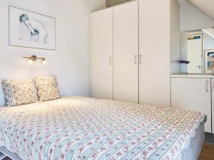 スヴァネケにある5 person holiday home in Svanekeのベッドルーム(ベッド1台、白いキャビネット付)