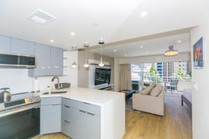 een keuken met witte kasten en een woonkamer bij Ilikai Tower 438 Lagoon View 1BR in Honolulu