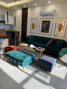 uma sala de estar com um sofá verde e mesas em The Presidential Suite Elysium Tower em Islamabad