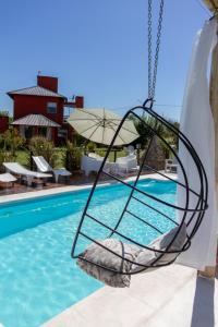 a swing hanging over a swimming pool at Punta Piedra cabañas & suites in Los Reartes