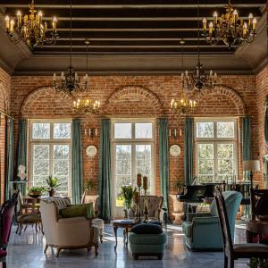 sala de estar con pared de ladrillo y piano en Dworek Atrium, en Tomaszów Lubelski