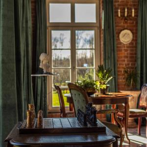 Habitación con mesa con sillas y ventana. en Dworek Atrium en Tomaszów Lubelski