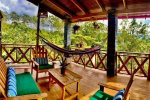a porch with a hammock and chairs on a deck at Villa Tortuga Constanza in Constanza