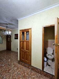 une chambre vide avec des toilettes et une porte dans l'établissement Hostal flor del lago, à Panajachel