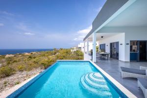 a swimming pool with a view of the ocean at Coral Estate Holidays in Willibrordus