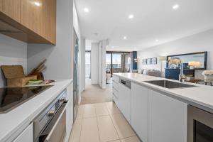 a kitchen with white cabinets and a counter top at Impeccable 1-Bed with Alfresco Dining in Barton in Kingston 