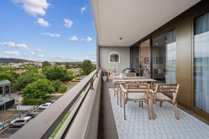 balcón con mesa, sillas y vistas a la ciudad en Impeccable 1-Bed with Alfresco Dining in Barton, en Kingston 