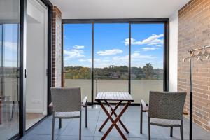 a patio with a table and chairs and a large window at Central location one bedroom in Chatswood in Sydney