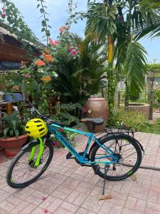 ein blaues Fahrrad mit gelbem Helm drauf. in der Unterkunft Ty Phu Miet Vuon Homestay - Entire Bungalow in Tây Ninh