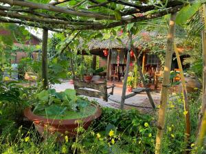 a garden with a fountain in the middle of a yard at Ty Phu Miet Vuon Homestay - Entire Bungalow in Tây Ninh