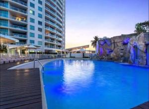 a large blue swimming pool next to a building at Massive Wings Apartment - 1 Block From Beach in Gold Coast