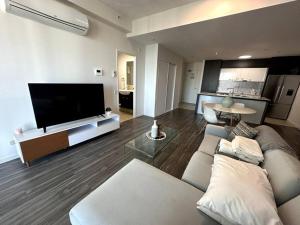 a living room with a couch and a flat screen tv at Massive Wings Apartment - 1 Block From Beach in Gold Coast