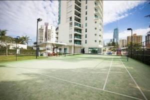 a tennis court in front of a tall building at Massive Wings Apartment - 1 Block From Beach in Gold Coast