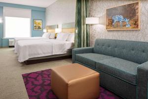 维代利亚Home2 Suites By Hilton Vidalia, Ga的配有床和沙发的酒店房间