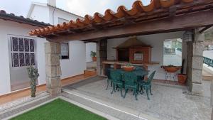 eine Außenterrasse mit einem grünen Tisch und Stühlen in der Unterkunft Orion Guest Villa Casais in Lousada