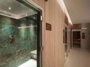 雷克雅未克Iceland Parliament Hotel, Curio Collection By Hilton的浴室设有步入式淋浴间,位于玻璃门旁