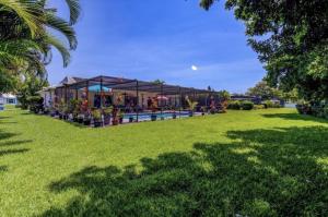 a building with a pool in a grass field at Cozy Pet-Friendly Private Pool Near Beaches in Bradenton