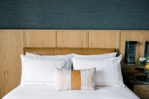 1 cama con almohadas blancas y cabecero de madera en Cloudland at McLemore Resort Lookout Mountain, Curio Hilton, en Rising Fawn
