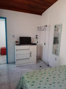 um quarto com uma cama, uma cómoda e um espelho em Casa da Bru pertinho da praia e da lagoa em Rio das Ostras
