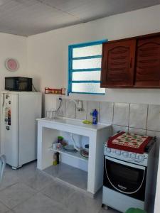 uma pequena cozinha com um lavatório e um fogão em Casa da Bru pertinho da praia e da lagoa em Rio das Ostras