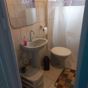 uma casa de banho com um lavatório e um WC em Casa da Bru pertinho da praia e da lagoa em Rio das Ostras