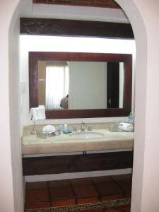 een badkamer met een wastafel en een grote spiegel bij Hotel Villa Mexicana Golf & Equestrian Resort in Villa del Pueblito