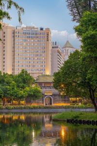 een skyline van de stad met hoge gebouwen en een vijver bij Yuexiu Hotel Guangzhou Curio Collection By Hilton, Free Shuttle during Canton Fair in Guangzhou