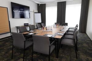 une salle de conférence avec une grande table et des chaises dans l'établissement Hotel Gut Matheshof, BW Signature Collection, à Rieden