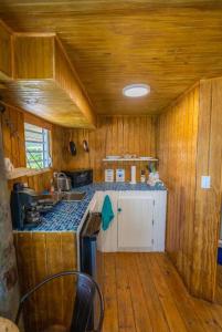 una pequeña cocina con paredes de madera y suelo de madera. en Ocean Front Villa 4 Studio, en Culebra