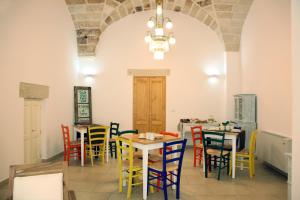 a restaurant with tables and chairs in a room at Manipinta B&B in Corigliano dʼOtranto