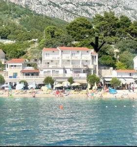 a group of people on the beach near a hotel at Aria in Baška Voda
