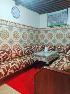 uma sala de estar com um sofá e um relógio na parede em House in Rabat medina best vibe em Rabat