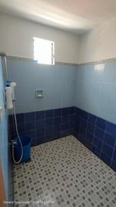 baño con suelo de baldosa azul y ventana en 3Js Place 30-mins from Tagaytay, en General Trias