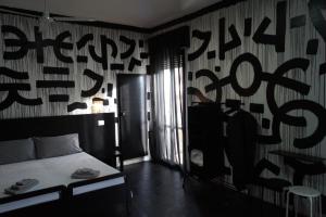 sypialnia z łóżkiem i ścianą z napisem w obiekcie Stupido Hotel Rimini w Rimini