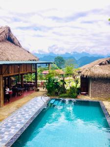 a swimming pool in front of a resort with mountains at Pù Luông Happy Home in Hương Bá Thước