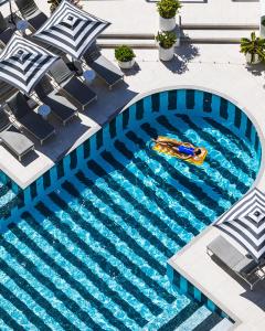 an overhead view of a swimming pool with a raft at QT Gold Coast in Gold Coast